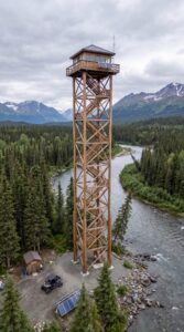 Would You Spend a Month Alone in This Remote Fire Tower for $8,000? Wooden_observation_tower_by_river_202608171359